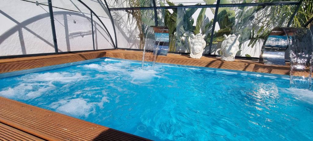 a swimming pool with a water fountain in it at La Maison della Valle in Agrigento