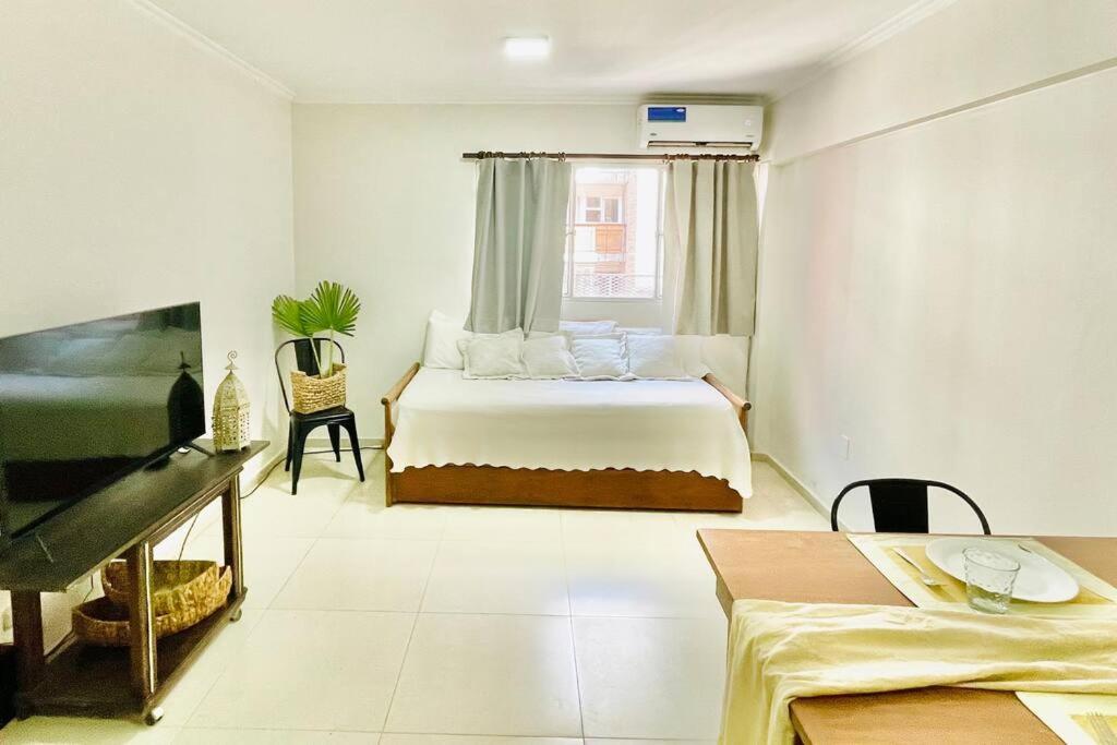 ein weißes Schlafzimmer mit einem Bett und einem Fenster in der Unterkunft Amplio Depto excelente ubicación in Mendoza