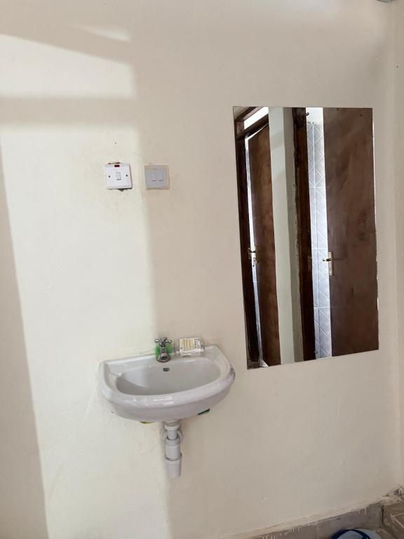a bathroom with a sink and a mirror at The comfortplace 303 Oak in Kericho