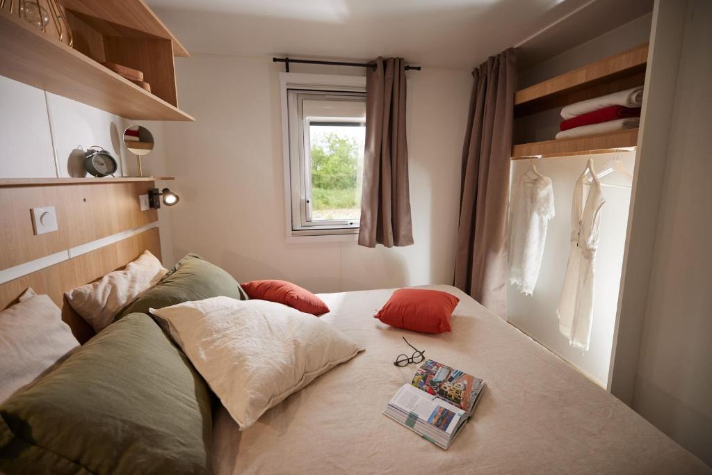 een slaapkamer met een bed met een boek erop bij Residence Marea Resort in Santa-Lucia-di-Moriani