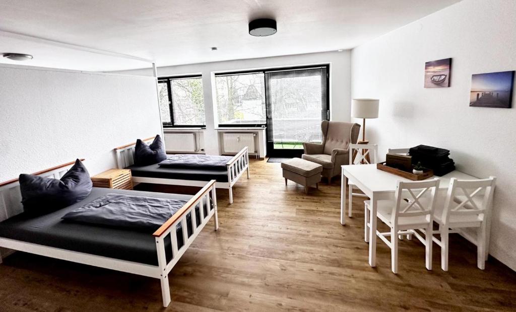 een kamer met drie bedden en een tafel en stoelen bij Moderne Ferienwohnungen in Kleve in Kleve