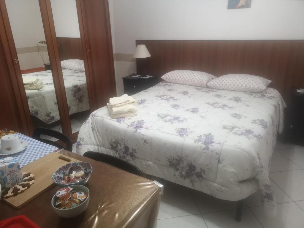 - une chambre avec un lit, une table et un miroir dans l'établissement Antico Portale - Host Roberto, à Regalbuto
