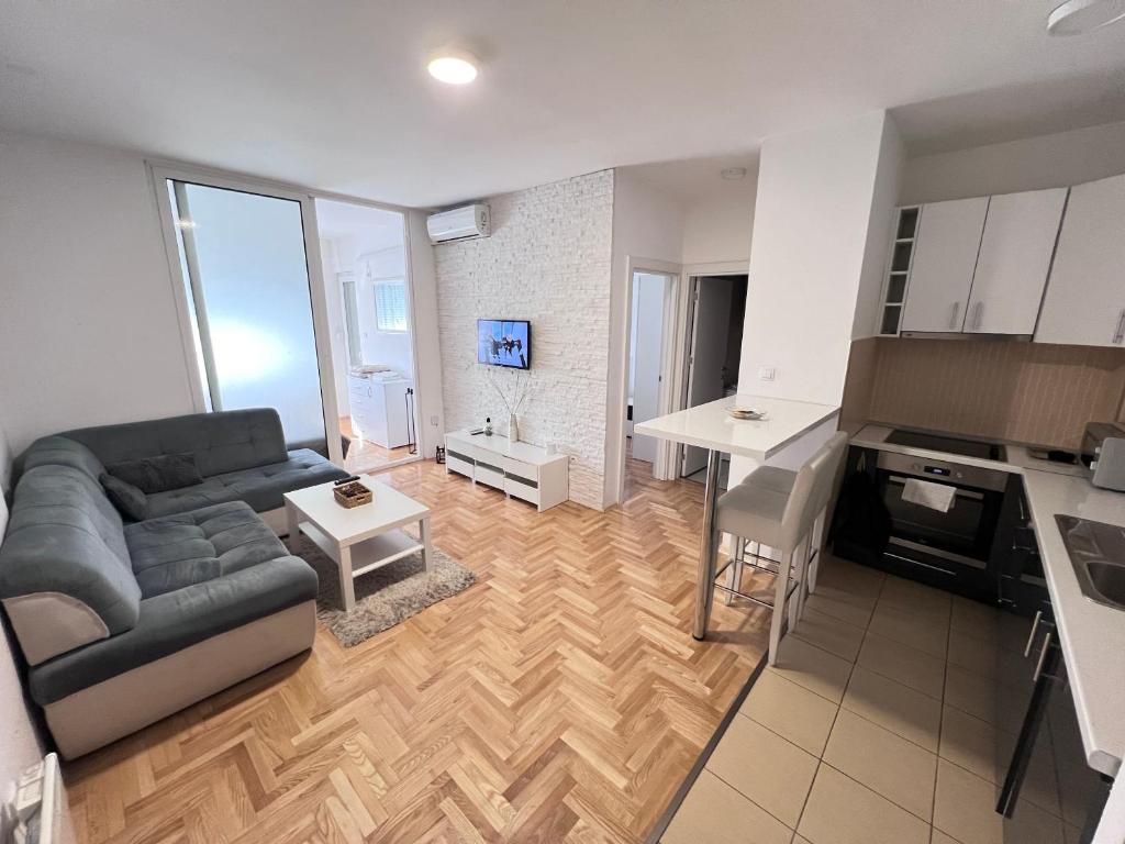 sala de estar amplia con sofá y cocina en Apartment 4th. Floor, en Banja Luka