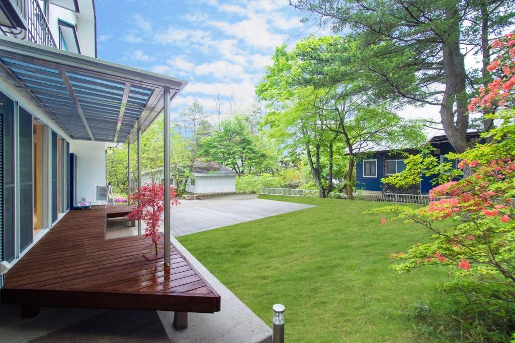 a porch with a wooden bench on a house at Private hot-spring Villa in Kusatsu in Kusatsu