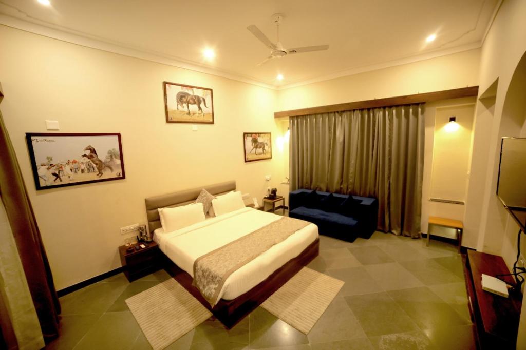 Habitación de hotel con cama y sofá en Dev Villa Resort en Rājsamand