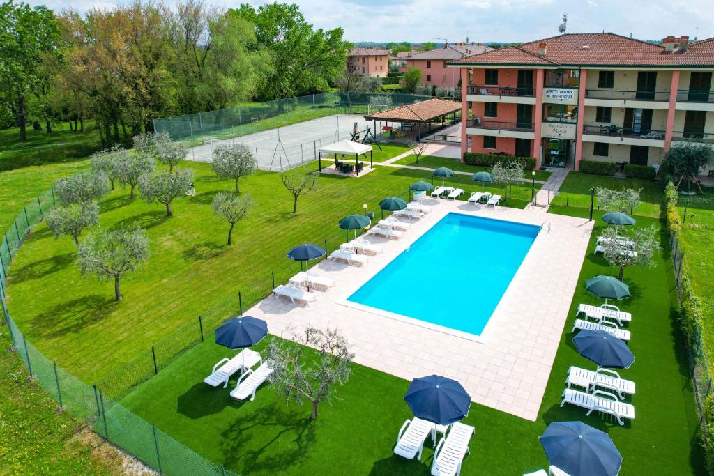 una vista aérea de una piscina con sillas y sombrillas en Residence Parco, en Sirmione