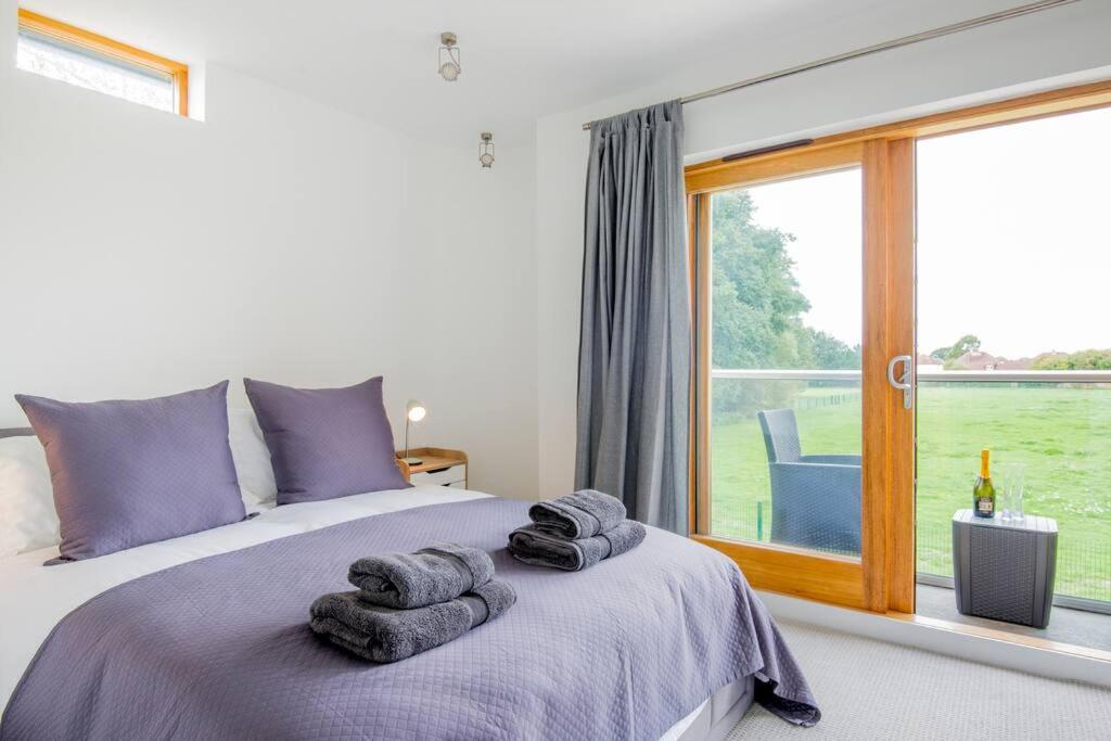 a bedroom with a large bed with towels on it at King Bed Joy Lane, Chichester near Goodwood in Chichester