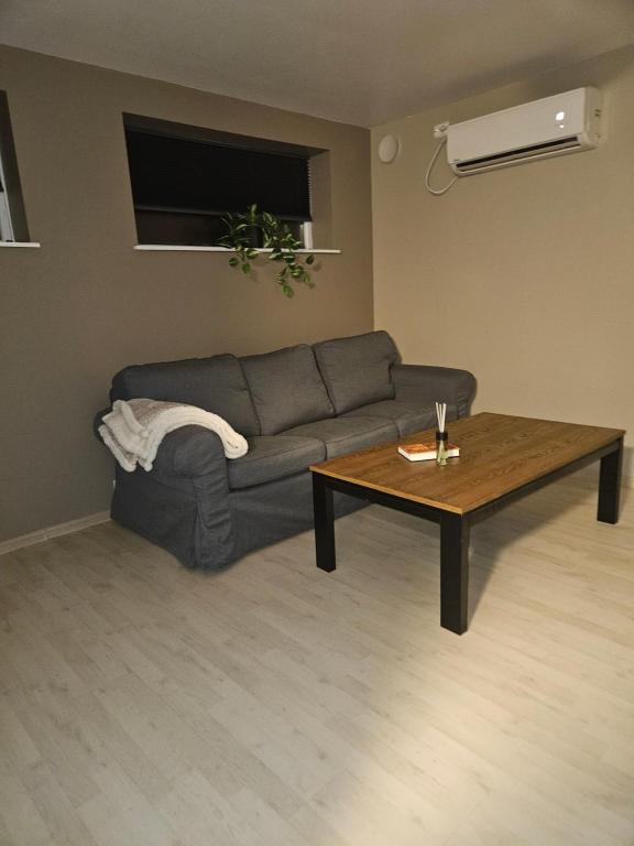 ein Wohnzimmer mit einem Sofa und einem Couchtisch in der Unterkunft Leilighet nær flyplass og Ålesund sentrum in Ytterland