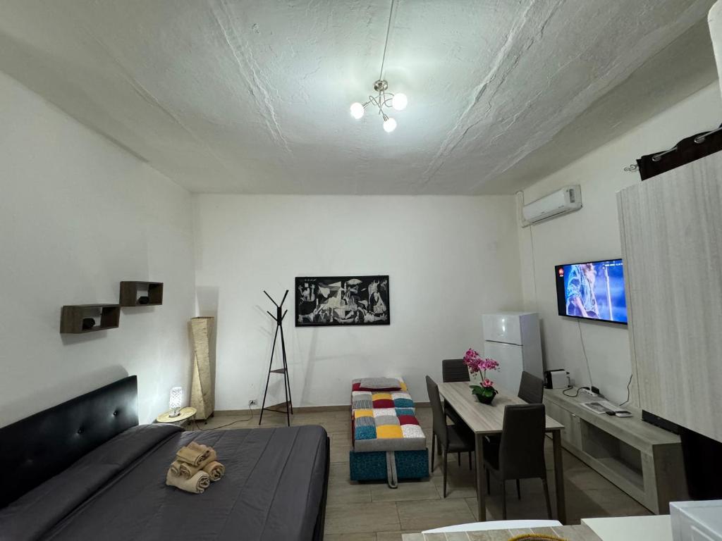 Habitación con cama, mesa y TV. en Civico10, en Sassari