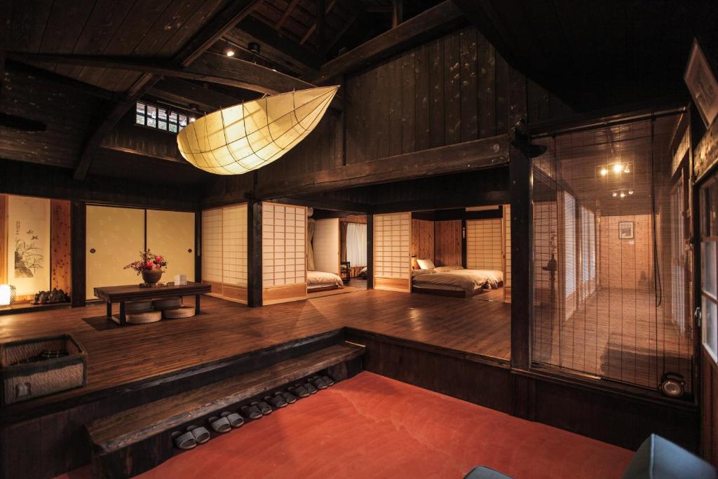 una sala de estar con una habitación grande con paredes de madera. en Ryunohara Hatago en Tanabe