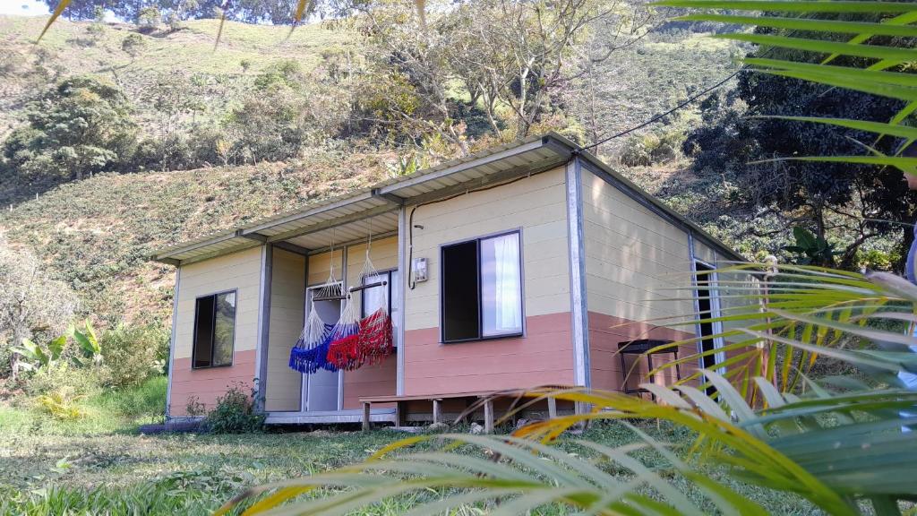 una casa rosa y blanca al lado de una colina en Cabaña La Guitarra, en Betania