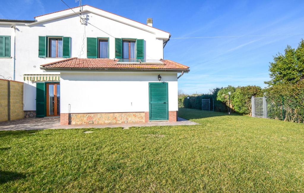 Casa blanca con persianas verdes y patio en 4 Bedroom Amazing Home In Marsiliana, en Marsiliana