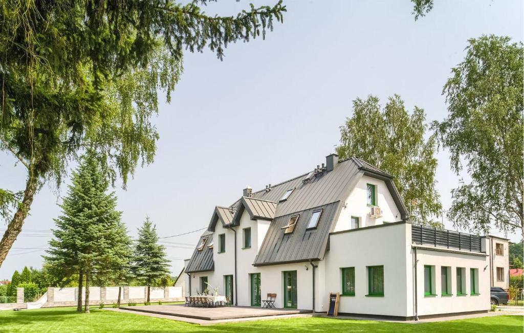 une maison blanche avec un toit gris dans l'établissement Lovely Apartment In Tlen With Kitchen, à Tleń
