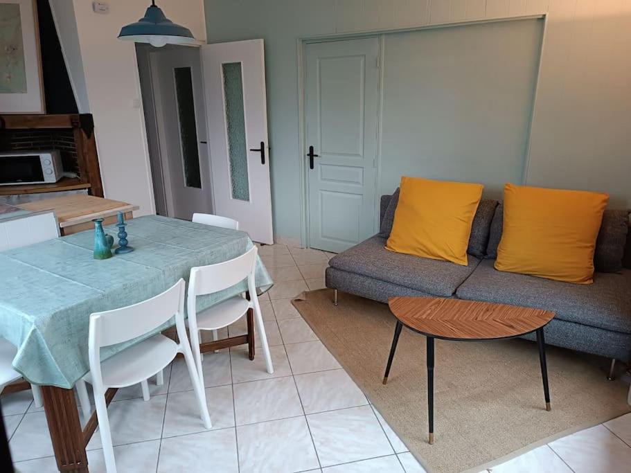 uma sala de estar com uma mesa e um sofá em Le Refuge Martin em Les Mazures