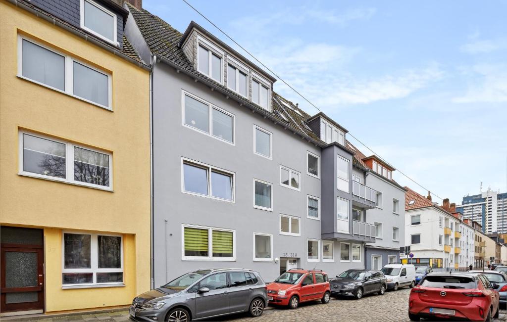 a row of buildings with cars parked in a parking lot at 2 Bedroom Nice Apartment In Bremerhaven in Bremerhaven