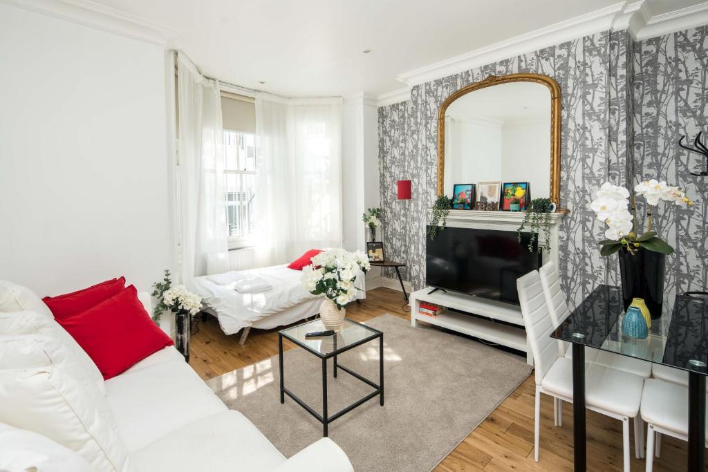 a living room with a white couch and a mirror at Marvellous Flat in Earls Court in London