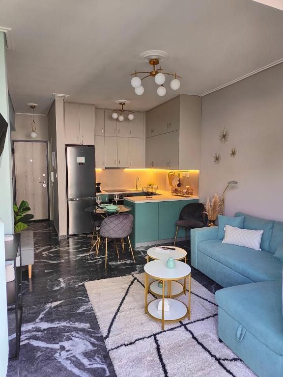uma sala de estar com um sofá azul e uma cozinha em Olivia Apartment-Private parking em Chalkida