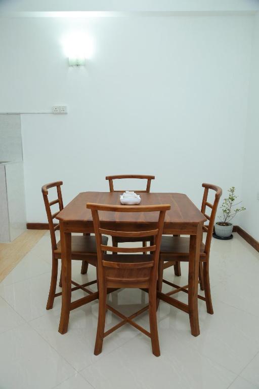 a wooden table with four chairs around it at Kandy DOWNTOWN in Katugastota