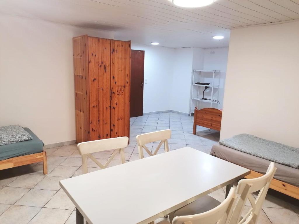 卡塞爾的住宿－SOUTERRAIN Monteur Arbeiter 2-Zimmer Wohnung in KASSEL，配有桌椅和橱柜的房间