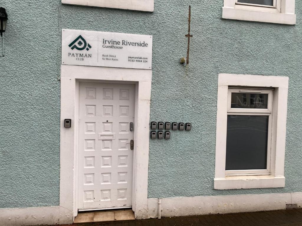 a blue building with a white door and a window at Irvine Riverside Guesthouse - Full House in Irvine