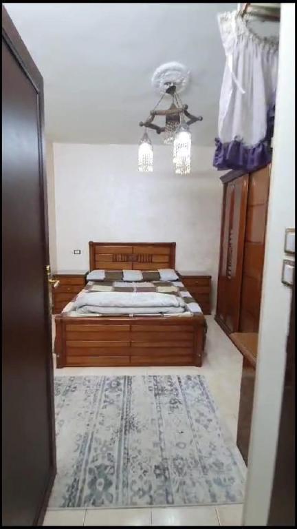 una camera con letto e lampadario a braccio di شقة مفروشة مميزة جدا a Mît Khamîs