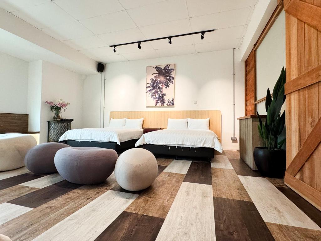 dwa łóżka w pokoju z 2 otomanami w obiekcie Inang Street Stay - Cheng Business Park w Malakce