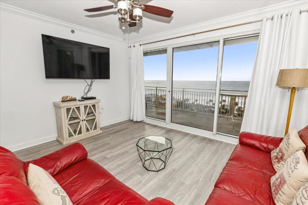 uma sala de estar com um sofá vermelho e uma grande janela em Sterling Shores 918 condo em Destin