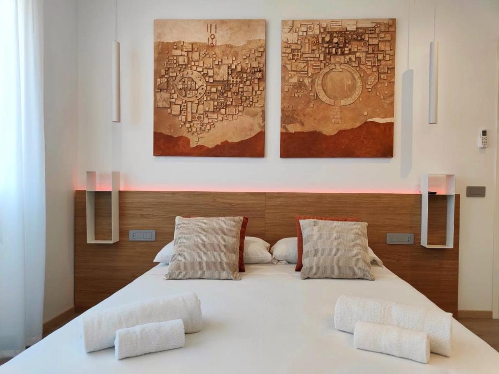 1 dormitorio con 1 cama blanca grande y 2 almohadas en Galleria Roma Art Guesthouse, en Oristano