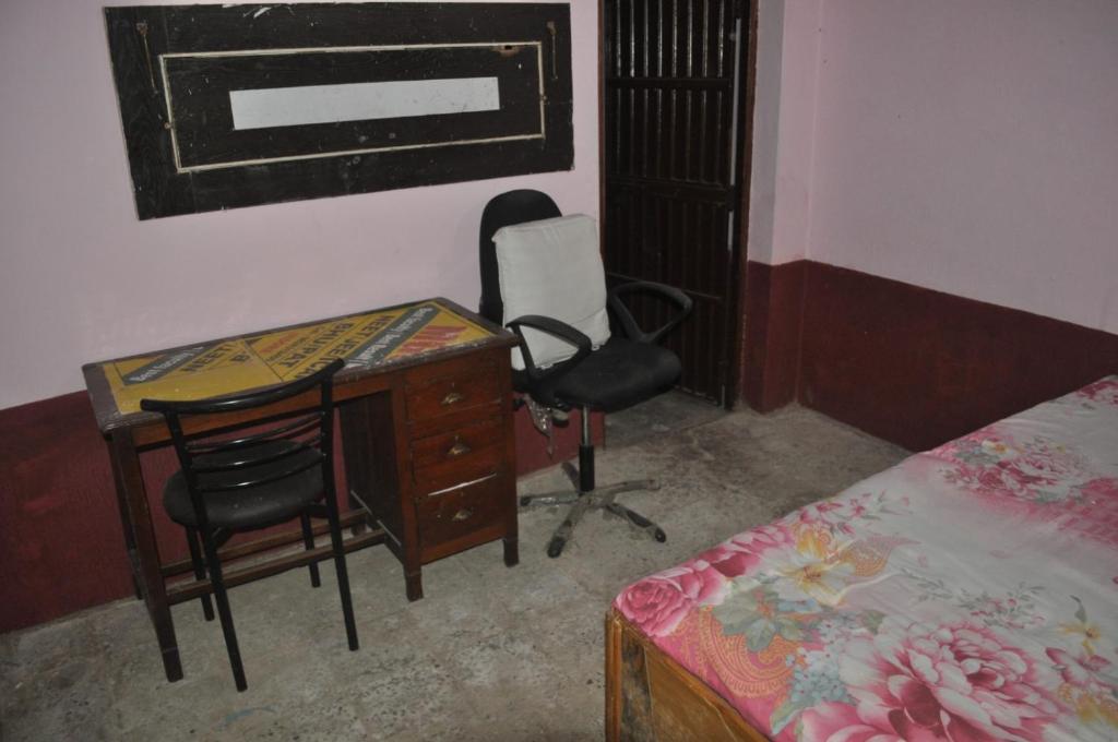 1 dormitorio con escritorio, silla y cama en Virndawan House en Maheshwar