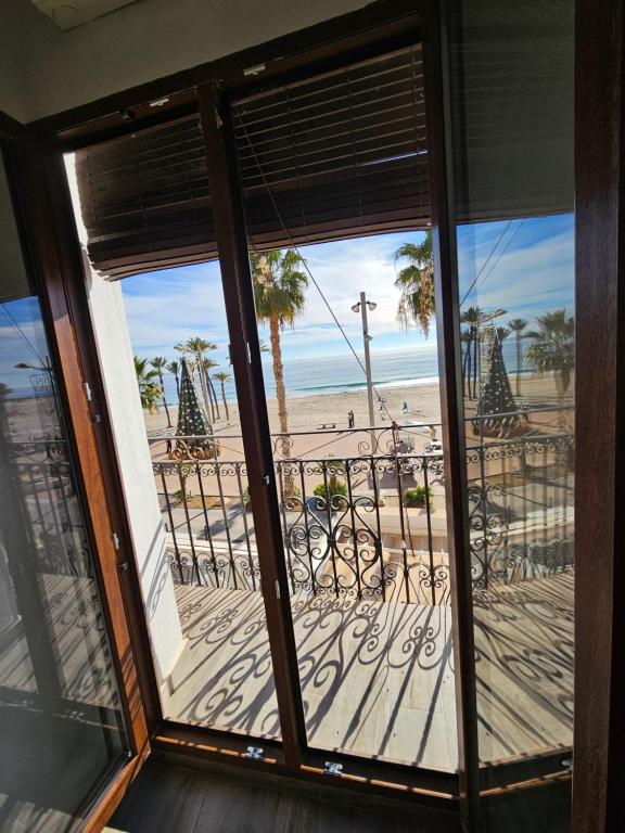 een kamer met uitzicht op het strand vanuit een raam bij H&B COSTABLANCA in Villajoyosa