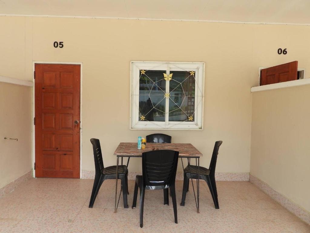 una sala da pranzo con tavolo, sedie e finestra di 888 private room family a Mu Si