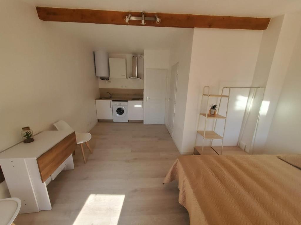 Cette chambre comprend un lit, une table et une cuisine. dans l'établissement Studio Cosy en plein centre ville, à Bédarieux