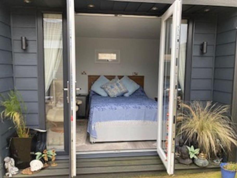 - une chambre avec un lit à l'intérieur d'une porte en verre dans l'établissement Beautiful new Garden Annexe, à Ashton-in-Makerfield