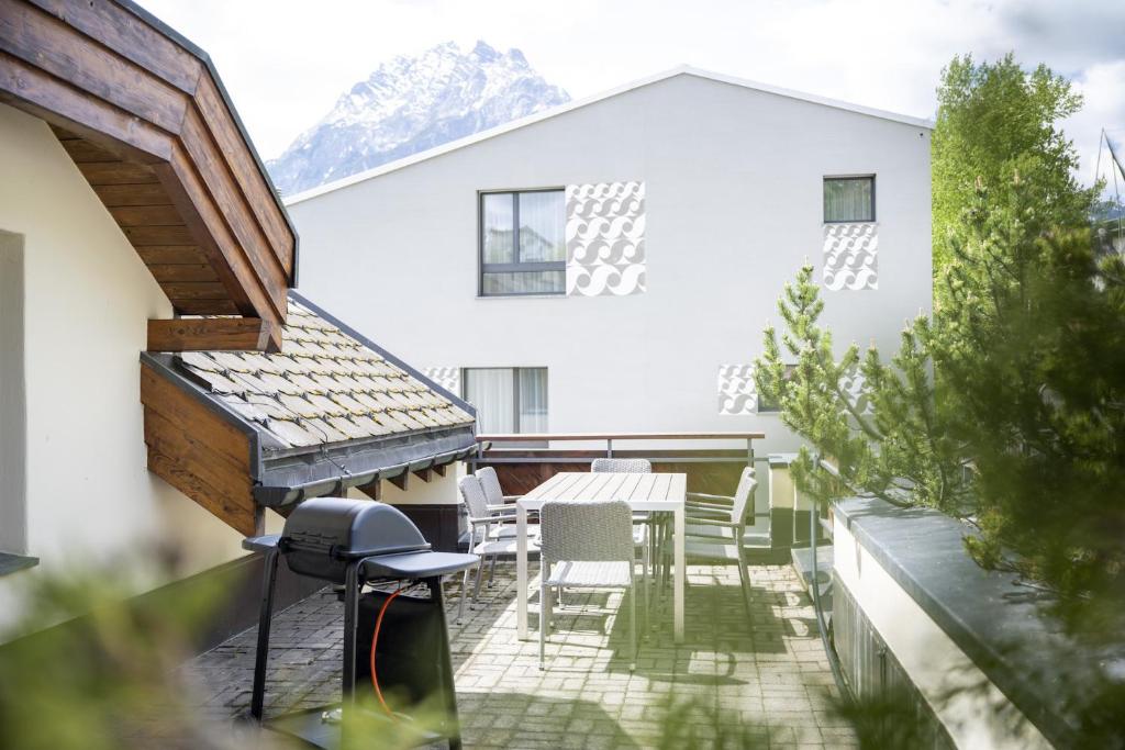 a balcony of a house with a table and chairs at Chasa Stradun 400 in Scuol