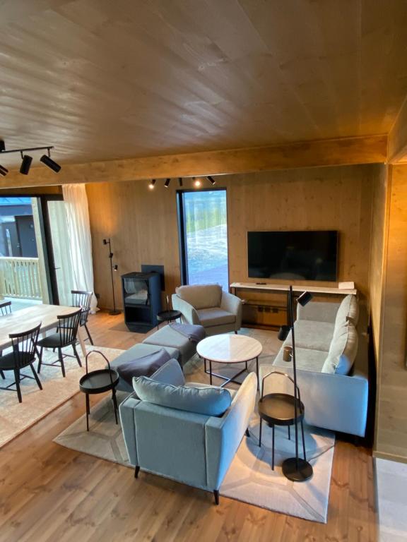 een woonkamer met banken en tafels en een tv bij Modern villa in North Park Villas, Idre in Idre