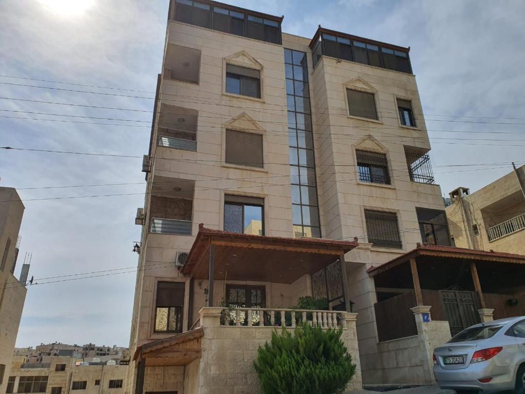 a building in the middle of a street at Shahed Apartment in Amman