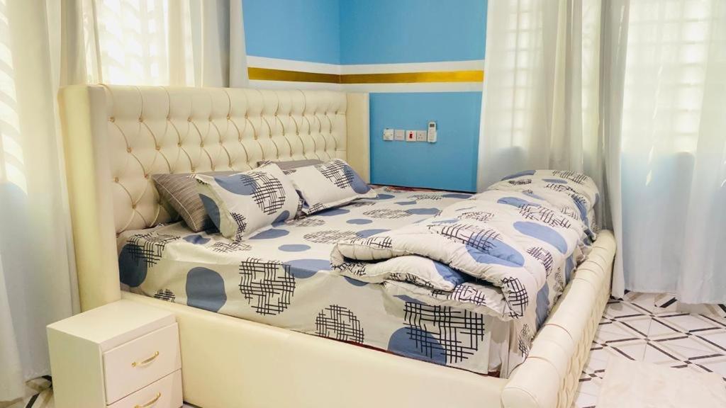 ein weißes Bett mit Kissen darauf im Schlafzimmer in der Unterkunft Favoured Apartment in Kwabenyan