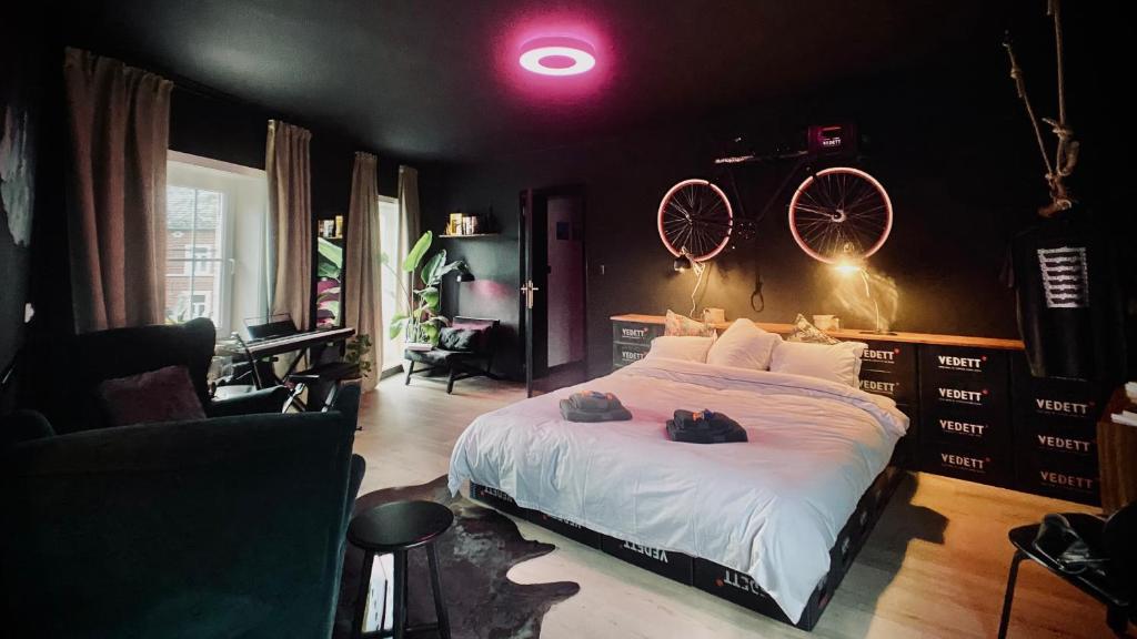 Les Chambres @ BisousBisous في Jodoigne: غرفة نوم مع سرير ودراجتين على الحائط