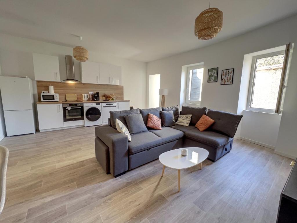 uma sala de estar com um sofá e uma mesa em Le "spacieux" en centre ville em Carpentras