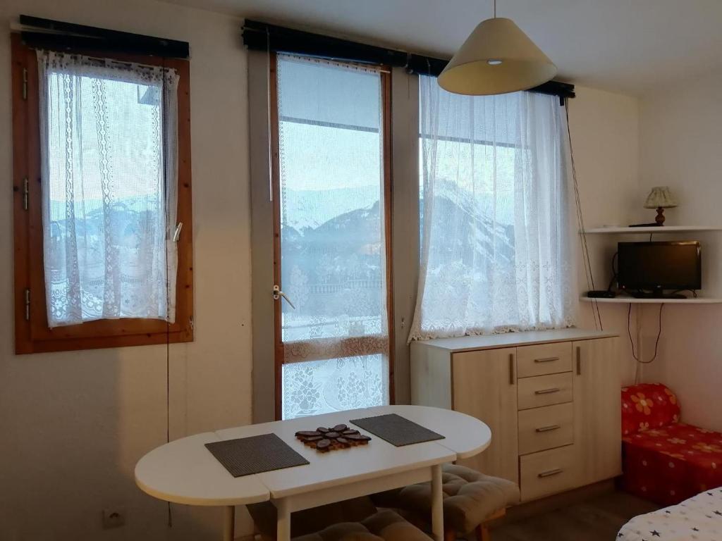 a small room with a table and two windows at Studio La Plagne Montalbert , 1 pièce, 3 personnes - FR-1-181-2544 in Aime-La Plagne