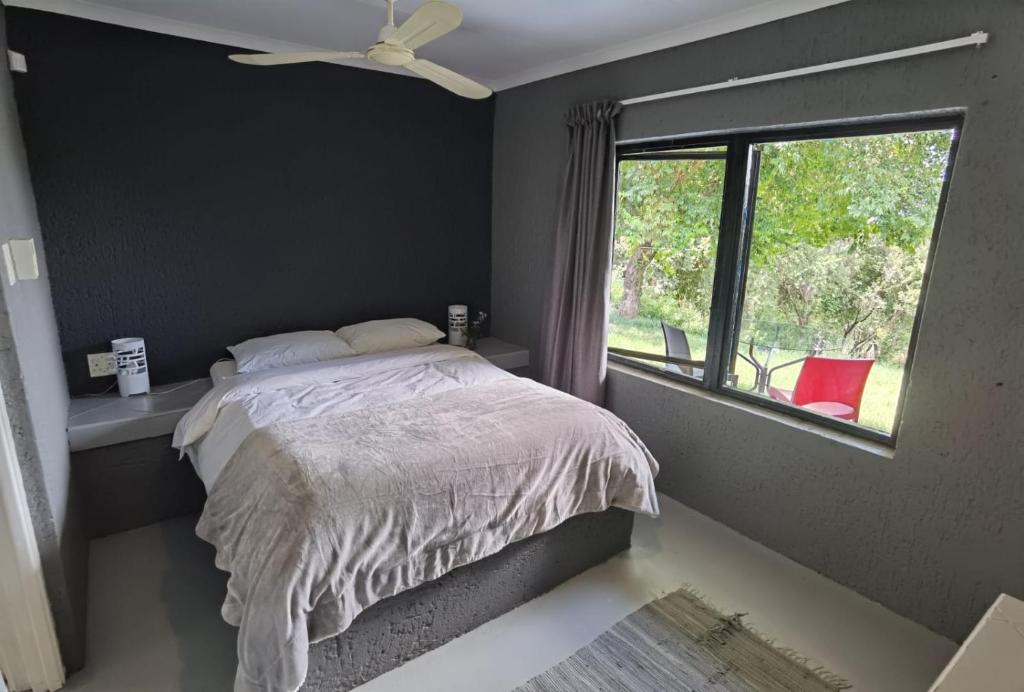 een slaapkamer met een bed en een raam bij Brae Allen in Hartbeespoort