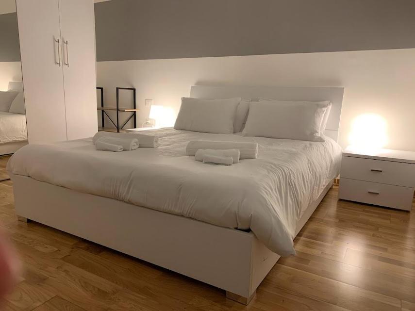 a bedroom with a large white bed with two pillows at Il Tasso Rooms & Apartments in Trieste