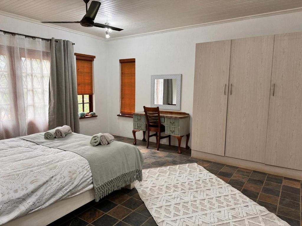 a bedroom with a bed and a desk in it at Aurora Bushbaby 2 in Centurion