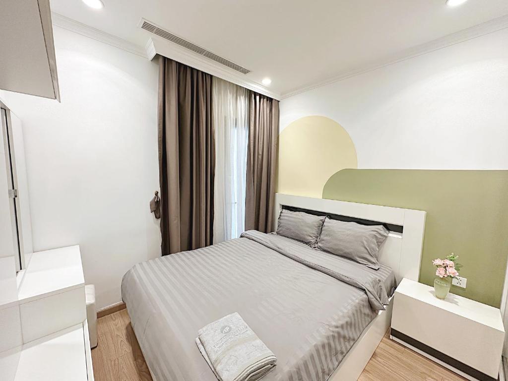 ein Schlafzimmer mit einem großen Bett in einem Zimmer in der Unterkunft Tpland Việt Nam - Vinhomes Times City- Park Hill in Hanoi