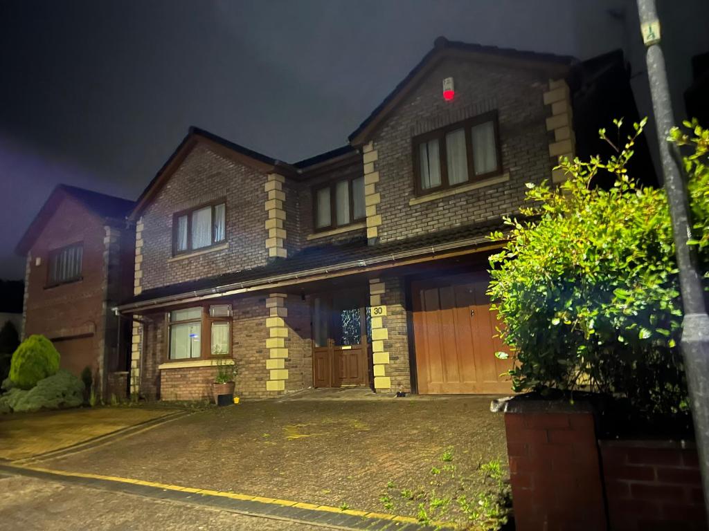 une maison en briques avec garage la nuit dans l'établissement Ocean Dream, à Swansea Bay