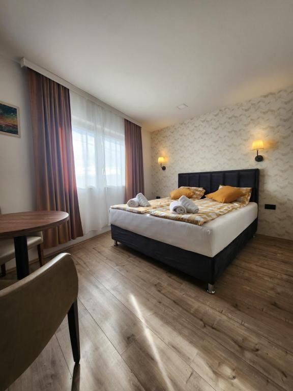 sypialnia z dużym łóżkiem i stołem w obiekcie Admiral 2 w mieście Valjevo