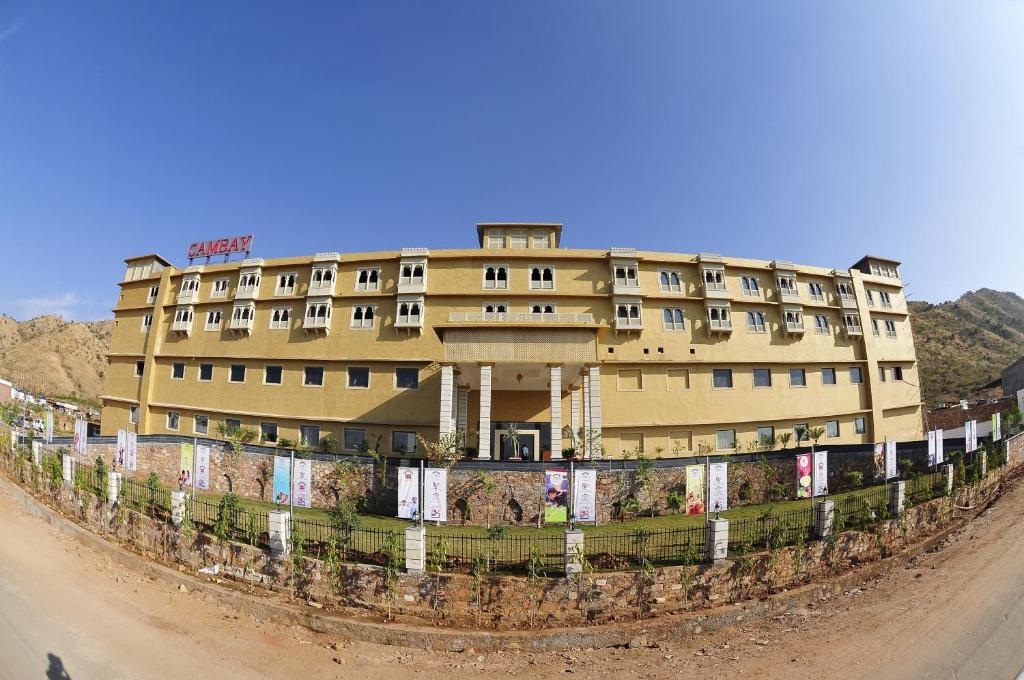 un gran edificio con una valla delante en Cambay Resort, Udaipur, en Udaipur