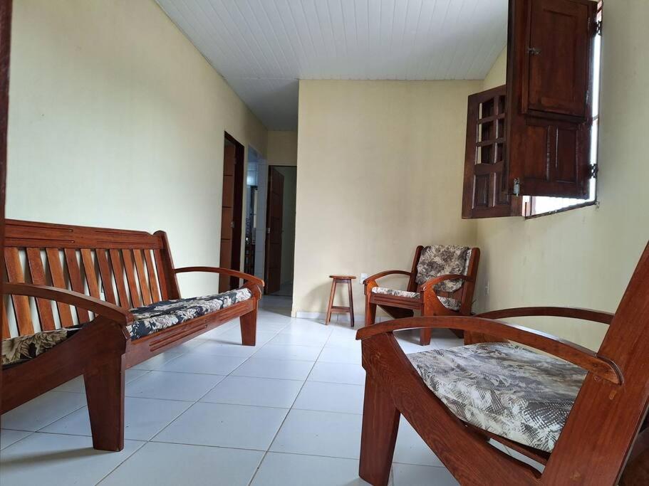 a room with two wooden benches and two chairs at Casa de Avinha in Sirinhaém