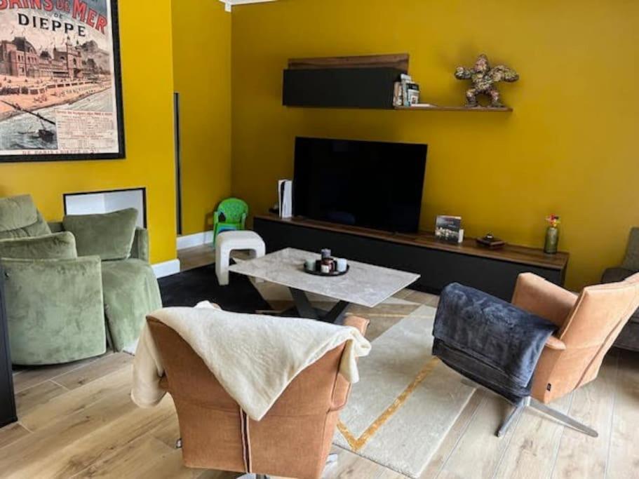 uma sala de estar com um sofá e uma televisão em Le cocon des cigognes em Dieppe