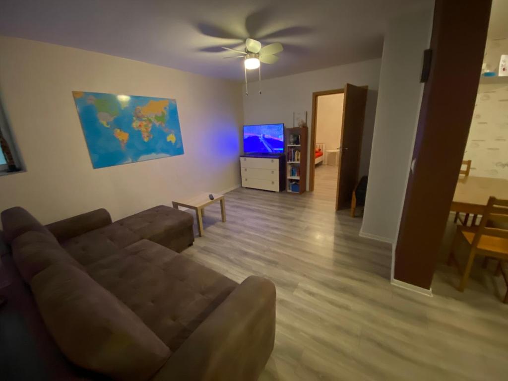 a living room with a couch and a flat screen tv at Ferienwohnung Houri in Neupotz